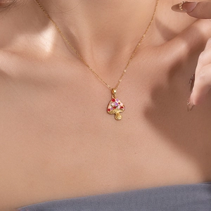 Chic gold mushroom pendant necklace with colorful polka dots on a female model