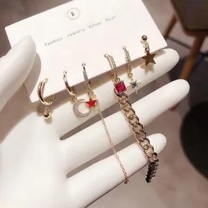 Detail of six gold earrings set featuring stars, moon charms and silver posts for women