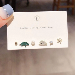 Detail of 6-piece earring set featuring dinosaur and floral designs with silver posts