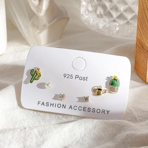 Detail of 6-piece earring set with cactus and watering can shapes on a white cloth