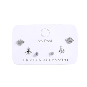 Detailed view of silver planet and airplane stud earrings set on a display card