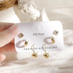 Three pairs of elegant gold earrings with stars and moon motifs on a 925 silver post card