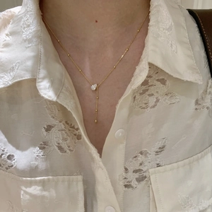 Elegant gold drop tassel necklace with water drop zirconia stone worn on a model