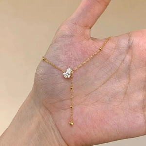 Elegant gold Y-shaped necklace with round beads and a teardrop-shaped zircon pendant