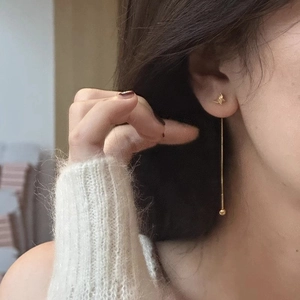 Elegant gold butterfly tassel earrings featuring long chain drop design on model