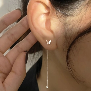 Detail of silver butterfly tassel earrings on model showing elegant drop chain style