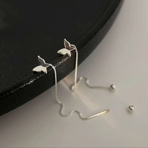 Close-up of minimalist butterfly threader earrings in s925 silver on black display