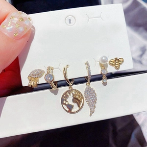 Six-piece gold earring set with zircon-encrusted stars and moon on a white display card