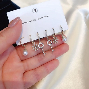 Detail view of 6-piece gold earring set with pearls, crystals, and key-shaped studs