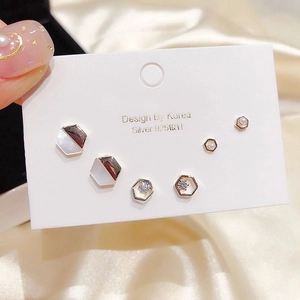 Detailed macro view of 925 silver earring set with zircons and shells on champagne silk