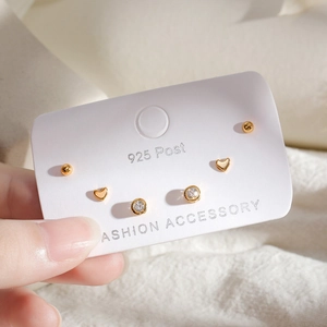 Close-up of golden S925 silver post earring set featuring heart and zircon stud details