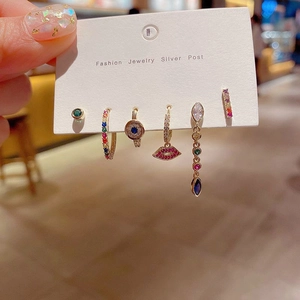 Detailed view of six-piece gold earring set with colorful zircon stones and silver posts