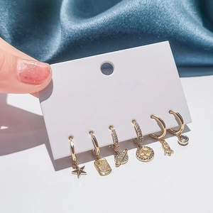 Set of 6 gold earrings featuring star moon and planet charms with cubic zirconia detail
