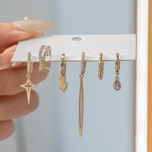 Close-up of 6-piece gold earring set with zircon stars and geometric pendants
