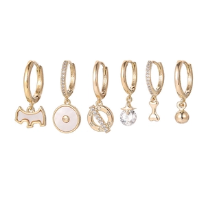 Detailed view of six gold-plated earrings featuring zircon-set star, moon and dog charms