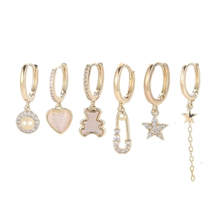 Detail of six-piece gold earring set with zircon star moon heart and bear pendants