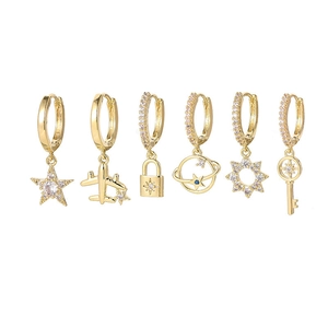 Detail of six gold hoop earrings featuring star, moon, plane, and zircon pendants