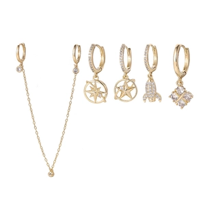 Detail of gold celestial earrings set featuring star, planet, and rocket motifs with zircons