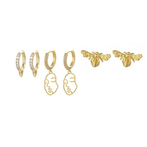 Detail of gold moon and star earring set with zircon inlays and artistic face designs
