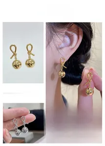 Detailed macro view of French vintage knot and ball earrings in gold and silver finish
