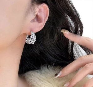 Macro detail of silver layered hoops with pavé rhinestones on a female model's ear