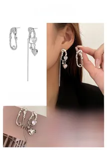 Asymmetrische silberne Sicherheitsnadel-Ohrringe mit Zirkonherz und Quasten-Details