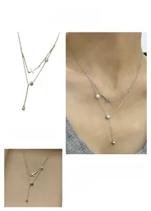 Vue détaillée du collier double rang argenté avec pendentif croix et perle élégante