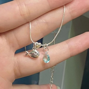 Silver necklace with fish and heart pendants plus a blue teardrop zircon stone