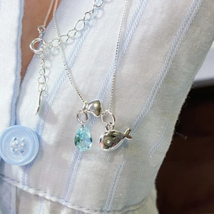 Silver necklace featuring a blue waterdrop zircon and a polished whale pendant on a chain