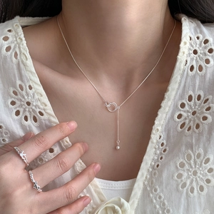 Silver interlocking rings necklace with tassel and matching bow ring on model