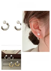 Detail view of the detachable C-shaped pearl earring in gold and silver finish options