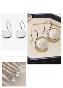 Macro shot of clear crystal sphere earrings with silver hooks for an elegant look