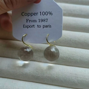 Elegant gold hook earrings with clear crystal glass balls in a French minimalist style