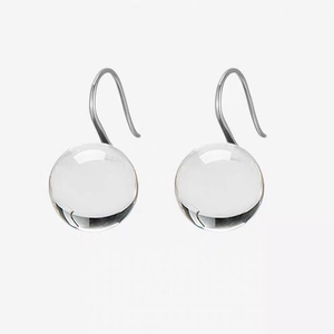 Macro view of clear crystal ball earrings with elegant silver metal hooks for daily wear