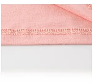 Dettaglio dell'orlo a doppia cucitura su un vestitino rosa in maglia di cotone