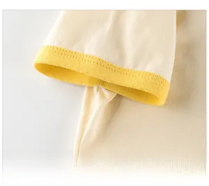 Detailed macro view of yellow ribbed cuffs on a beige cotton short-sleeve baby t-shirt