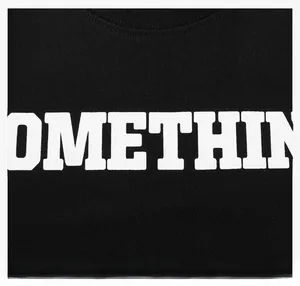 Detailed close-up of white letter print on a black cotton t-shirt fabric texture