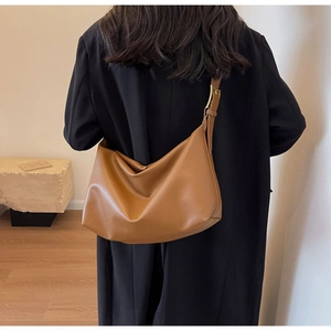 Detail of brown litchi pattern leather tote with adjustable wide shoulder strap