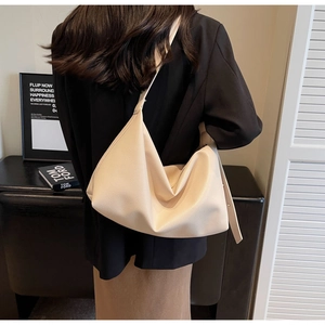 Detailed view of milk white lychee texture leather hobo bag on a model shoulder