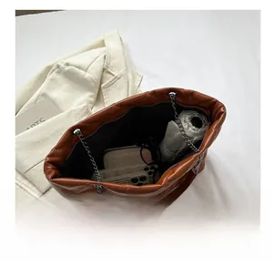 Vista interna del bolso tote acolchado marrón con capacidad para móvil y cartera