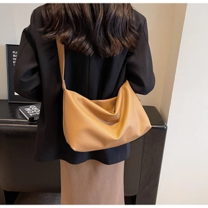 Detail of caramel lychee grain leather tote bag showing slouchy texture and wide strap