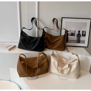 Detail of four hobo bags in assorted colors featuring litchi grain leather texture