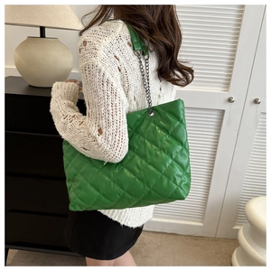 Detalle del bolso tote acolchado verde brillante con correa de cadena y rombos