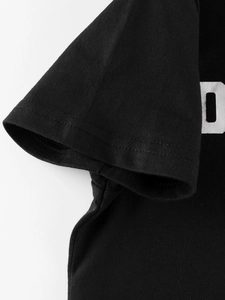 Detail of double-needle stitching and cotton knit texture on a black kids' short sleeve t-shirt