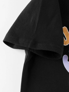 Macro detail of black cotton boy's t-shirt showing sleeve cuff and double-stitched seams