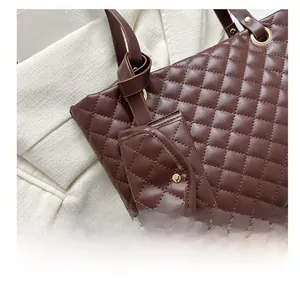Detail of brown quilted tote bag with diamond lattice pattern and metal ring buckle
