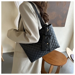 Close-up of black quilted tote bag with a small matching round zipper pouch