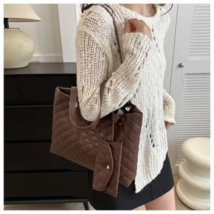 Detail of a large brown quilted tote bag with matching mini pouch and shoulder straps