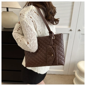 Detail of dark brown quilted tote bag with knot strap and matching small pouch