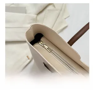 Detail view of premium golden smooth metal zipper on minimalist cream tote bag